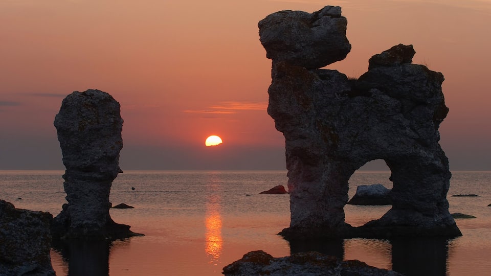 Gotland County which includes a sunset, a sandy beach and rocky coastline