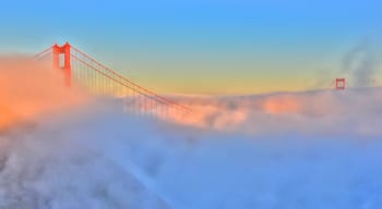 Golden Gate Bridge showing mist or fog and a bridge
