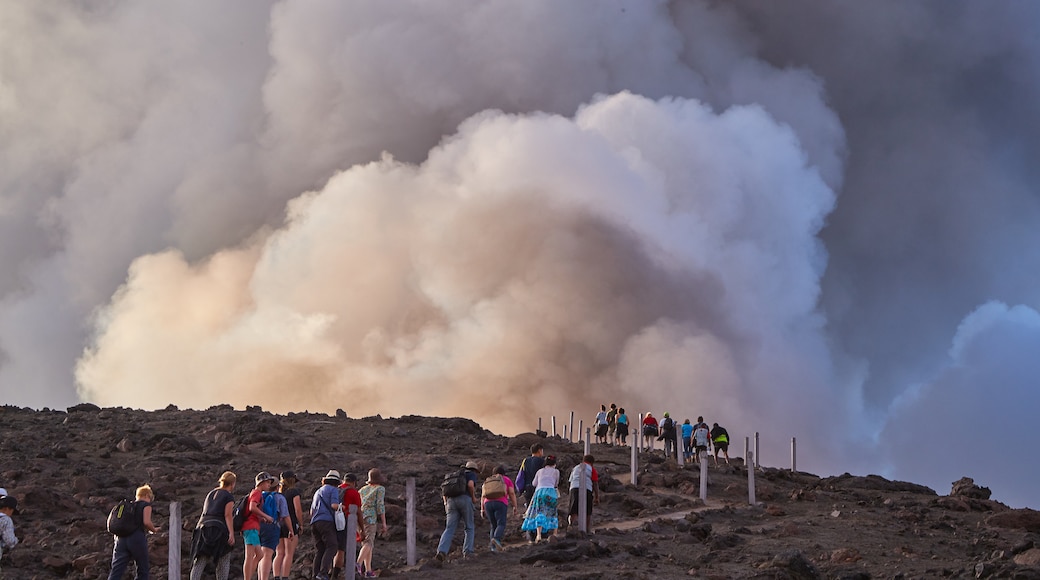 Mt. Yasur mostrando montanhas assim como um pequeno grupo de pessoas