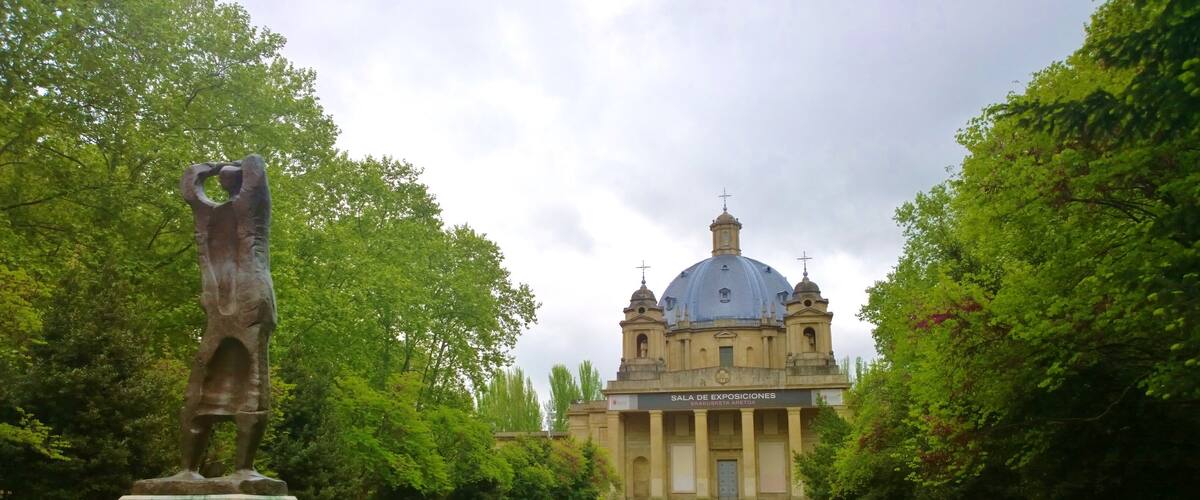 Pamplona mostrando una iglesia o catedral, un jardín y una estatua o escultura