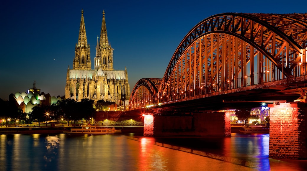 Hohenzollern Bridge which includes a church or cathedral, night scenes and a river or creek