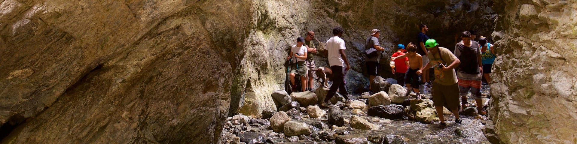 Zapata Falls showing a gorge or canyon as well as a small group of people