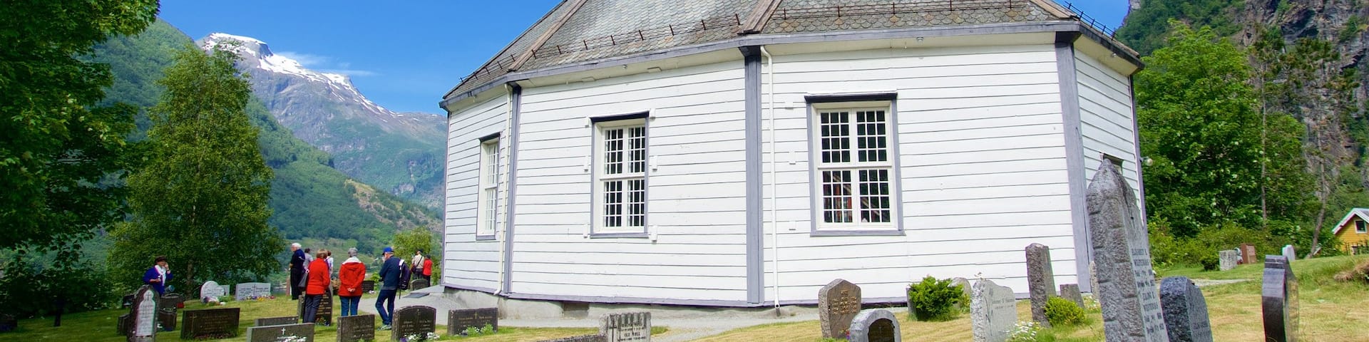 Geiranger featuring a cemetery and a church or cathedral as well as a small group of people
