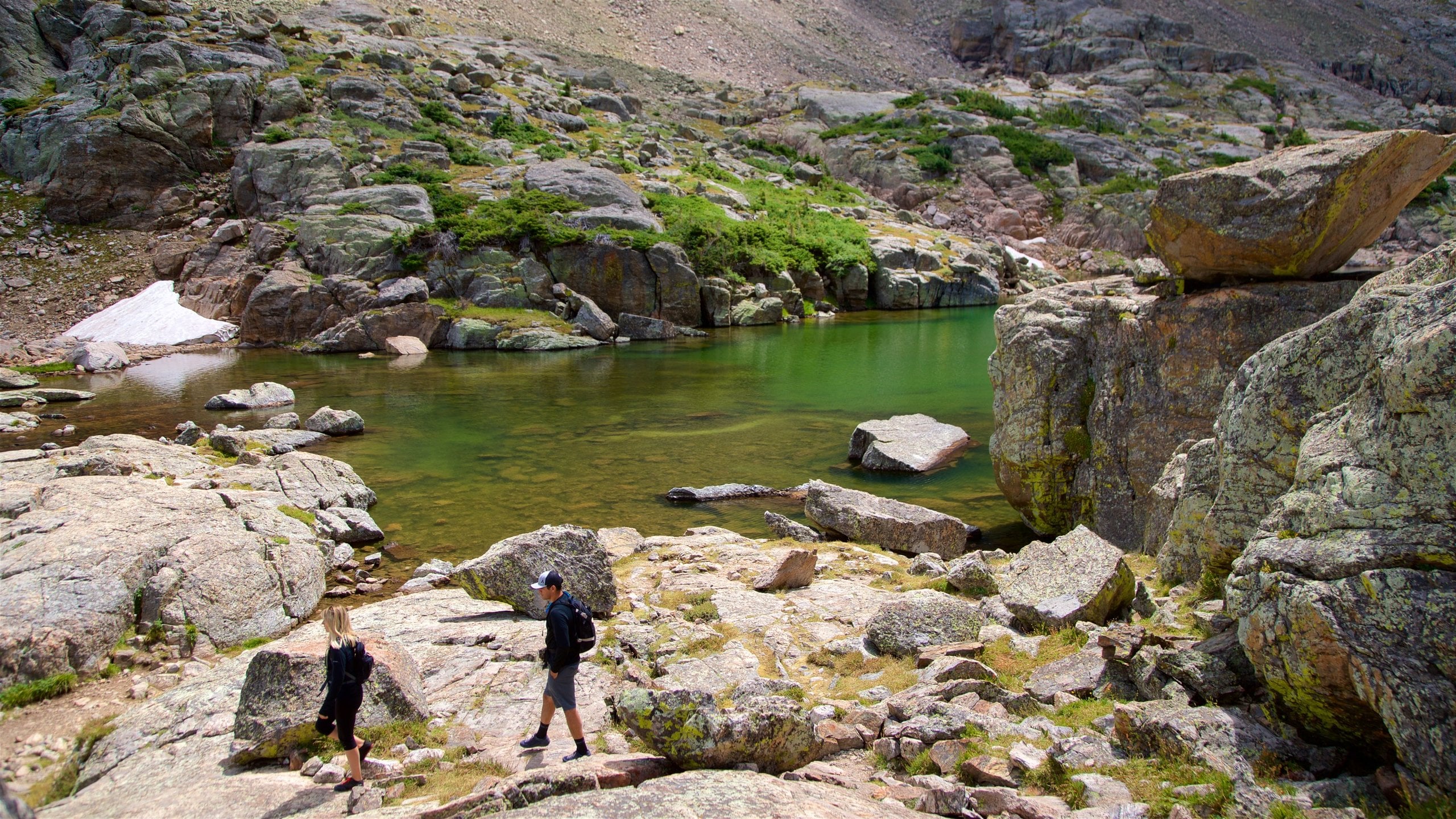 Estes Park ofreciendo escenas tranquilas y un lago o abrevadero y también una pareja