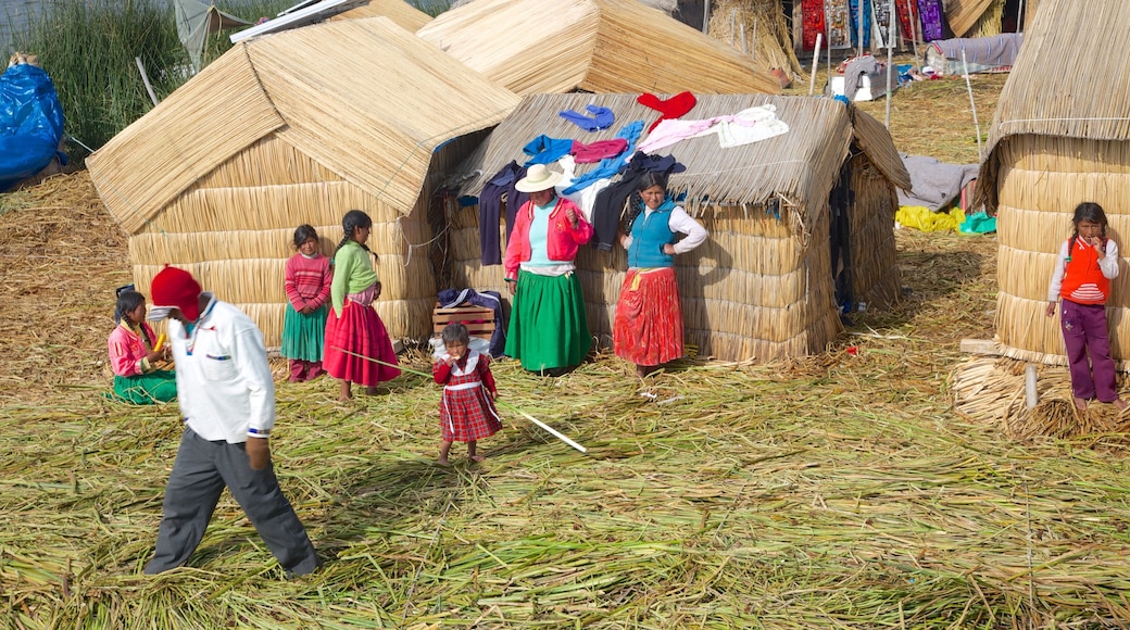 Lake Titicaca ofreciendo una pequeña ciudad o pueblo y también un pequeño grupo de personas