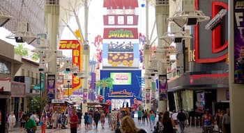 Downtown Las Vegas che include segnaletica cosi come un piccolo gruppo di persone