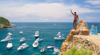 Acantilado La Quebrada ofreciendo botes y una bahía o un puerto y también un hombre