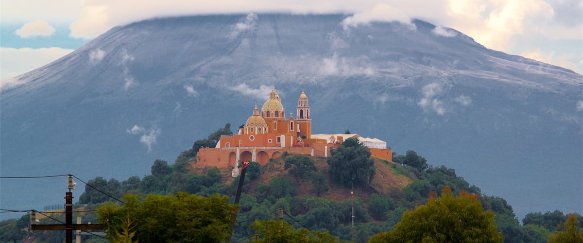 La Virgen de los Remedios Sanctuary featuring mountains, heritage elements and mist or fog