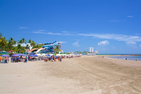 Strand von Mocambo welches beinhaltet Strand sowie groĂe Menschengruppe