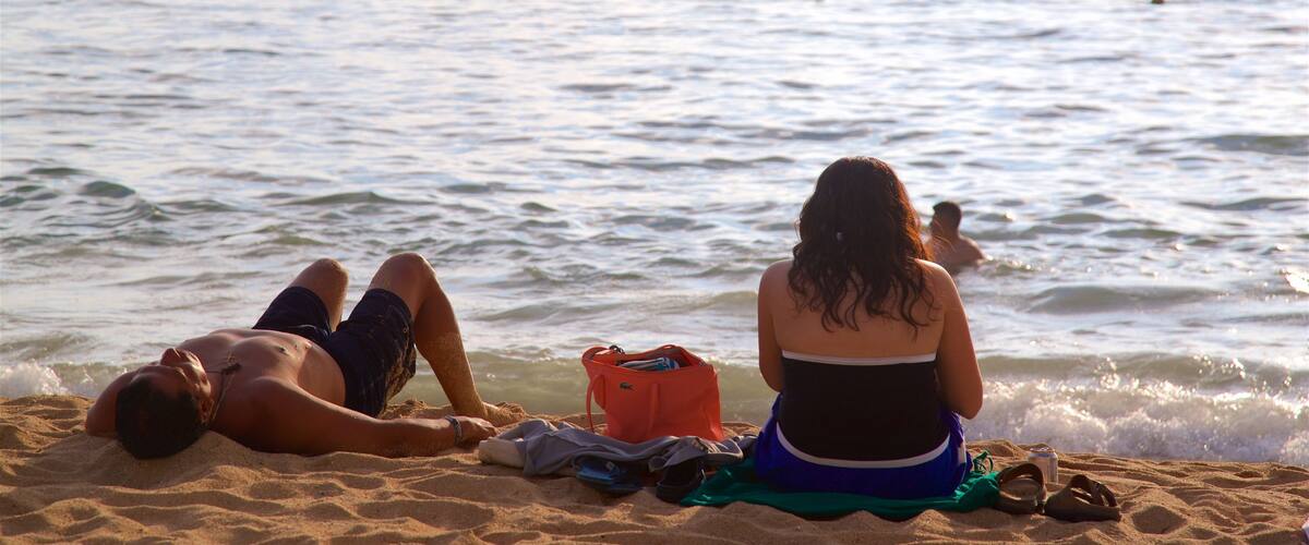 Icacos Strand som viser en sandstrand og udsigt over kystområde såvel som en familie