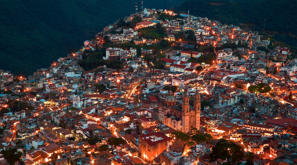 Santa Prisca Cathedral showing night scenes and a city