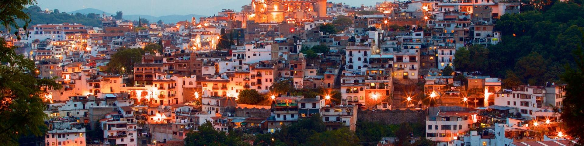 Santa Prisca Cathedral which includes a sunset, landscape views and a city
