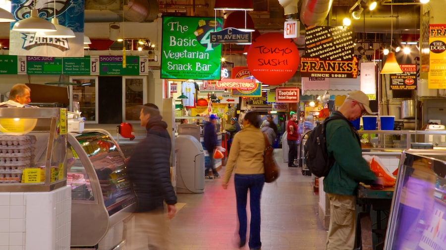 Interior view of Reading Terminal Market with food stalls and visitors exploring the historic space.