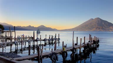 Guatemala showing mountains, a lake or waterhole and a sunset