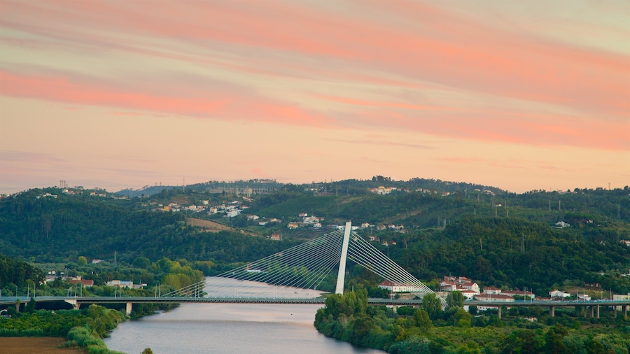 Coimbra som viser landskap, elv eller bekk og solnedgang