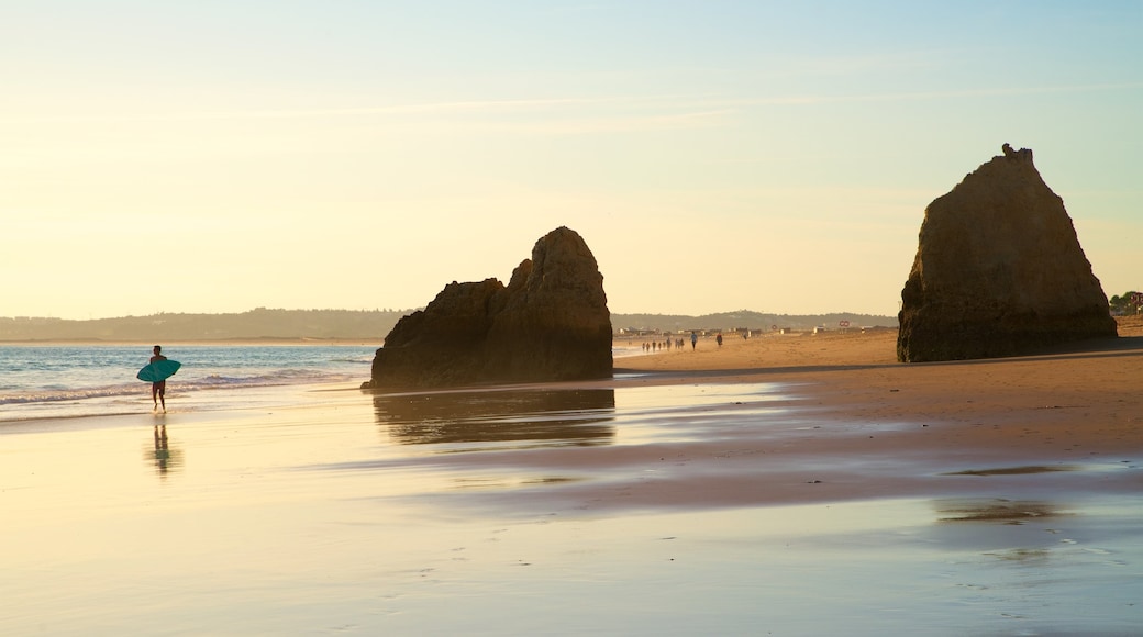 Tres Irmaos Beach showing a sandy beach, a sunset and rugged coastline