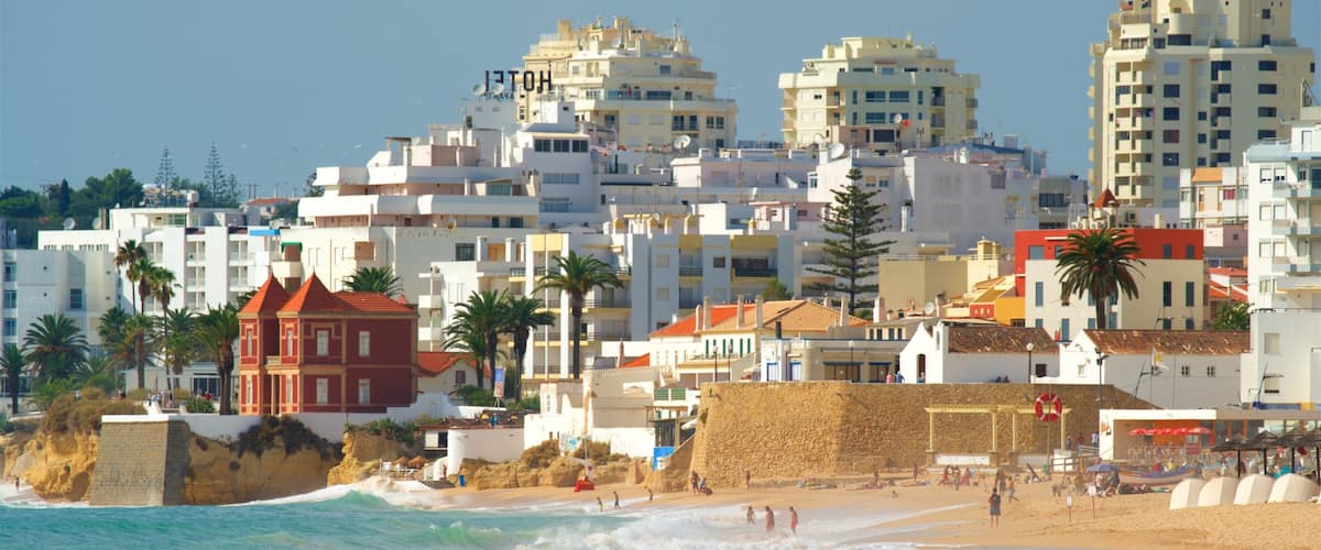 Salgados Beach showing waves, a sandy beach and a city