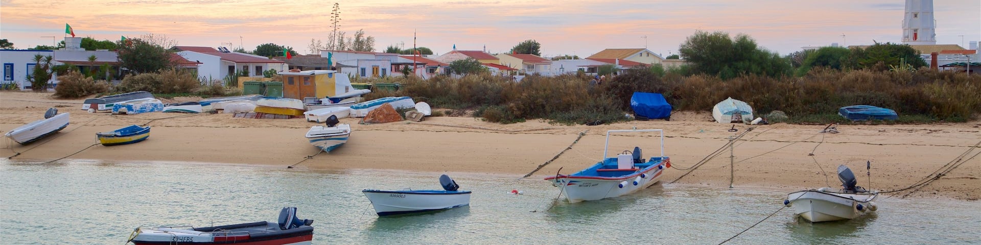Faro which includes a sunset, a lighthouse and a sandy beach