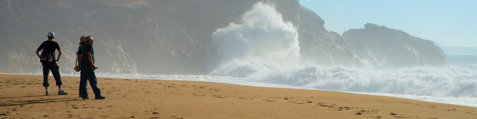Norte Beach featuring a sandy beach, surf and rocky coastline
