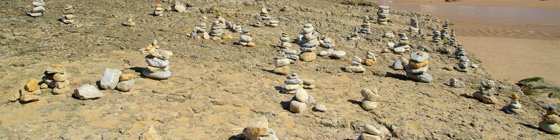 Macas Beach which includes a beach, rocky coastline and a coastal town
