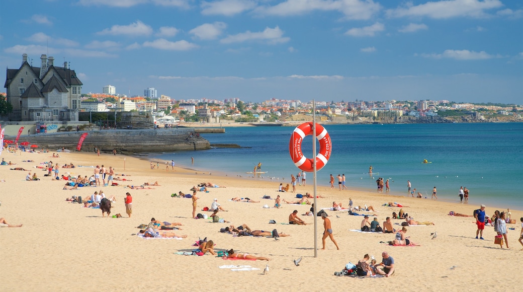 Cascais which includes a sandy beach and general coastal views as well as a small group of people