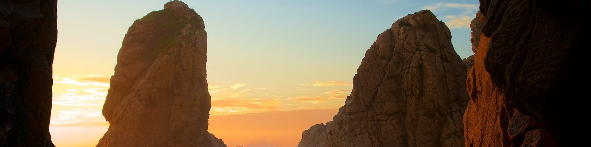 Ursa Beach featuring surf, a sunset and rugged coastline
