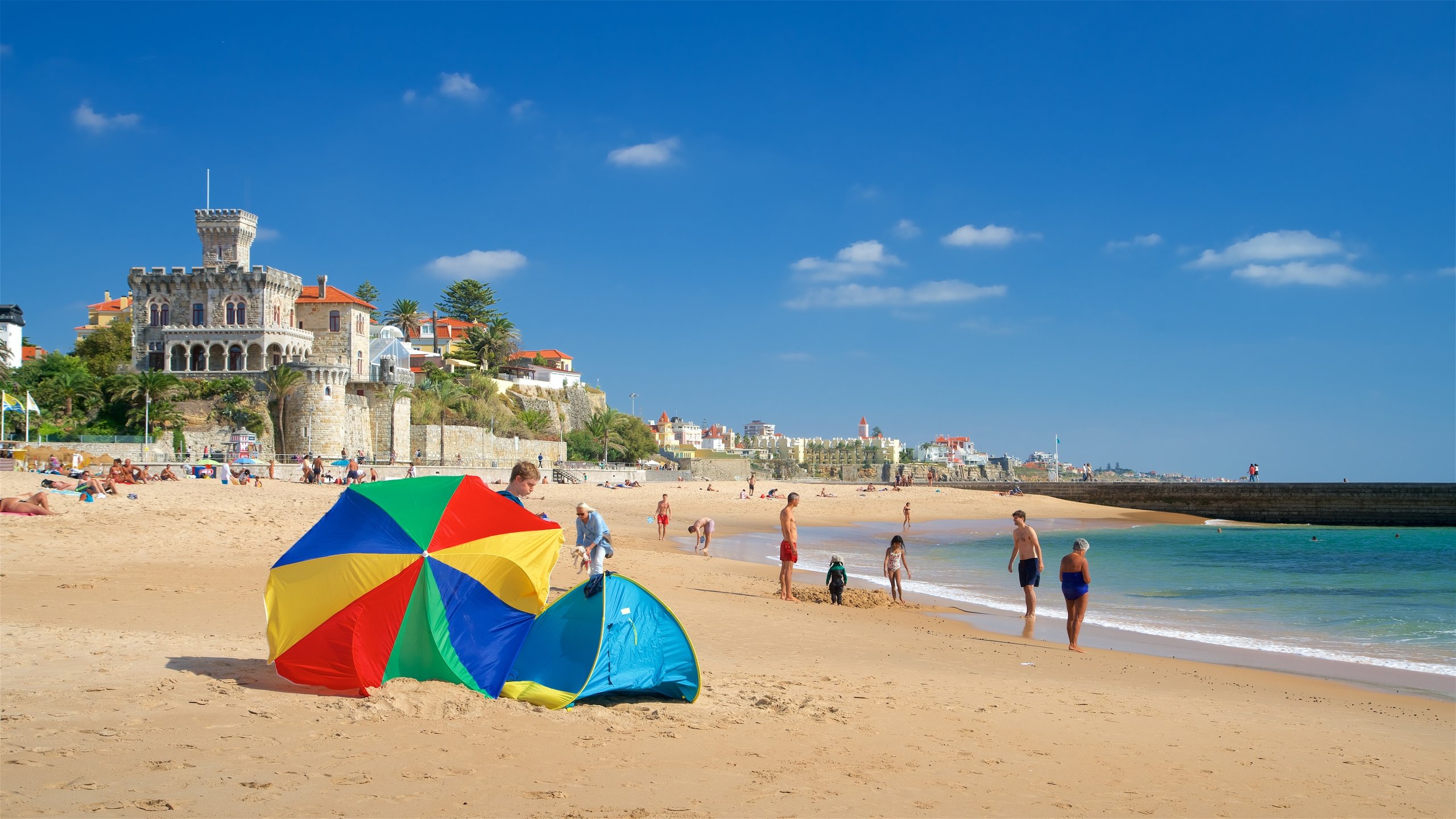 Tamariz Beach which includes general coastal views and a beach as well as a small group of people