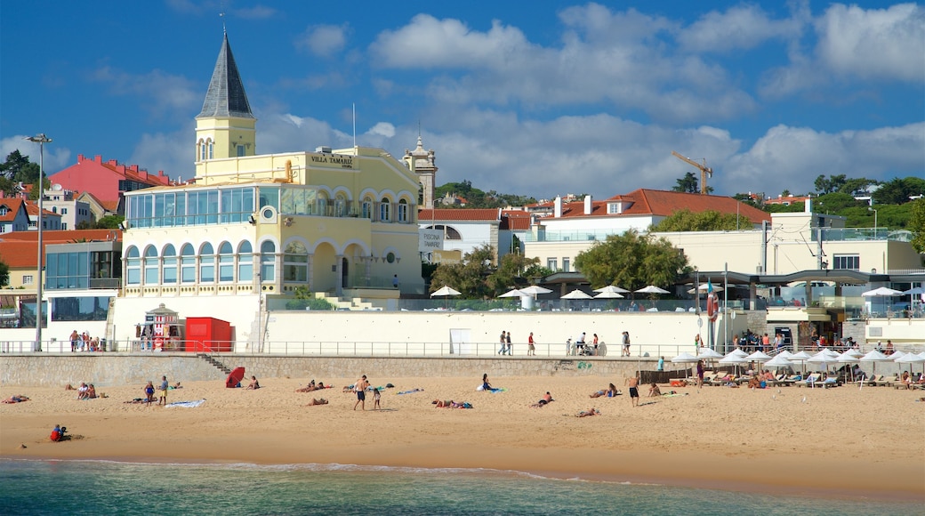 Praia do Tamariz caracterizando paisagens litorâneas e uma praia de areia assim como um pequeno grupo de pessoas