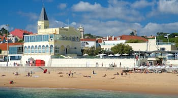 Praia do Tamariz caracterizando paisagens litorâneas e uma praia de areia assim como um pequeno grupo de pessoas