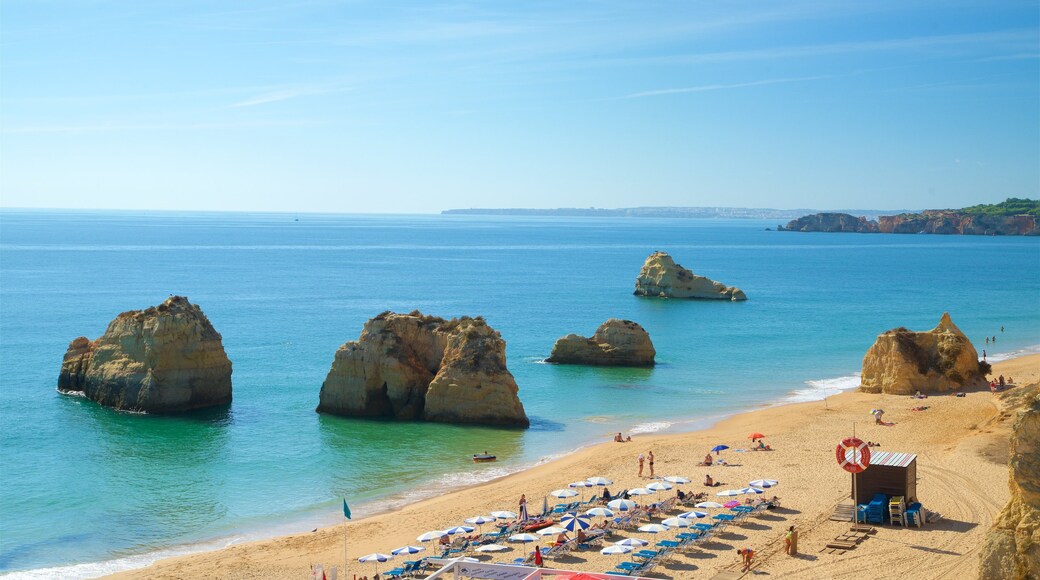 Portimao featuring general coastal views and rugged coastline as well as a small group of people
