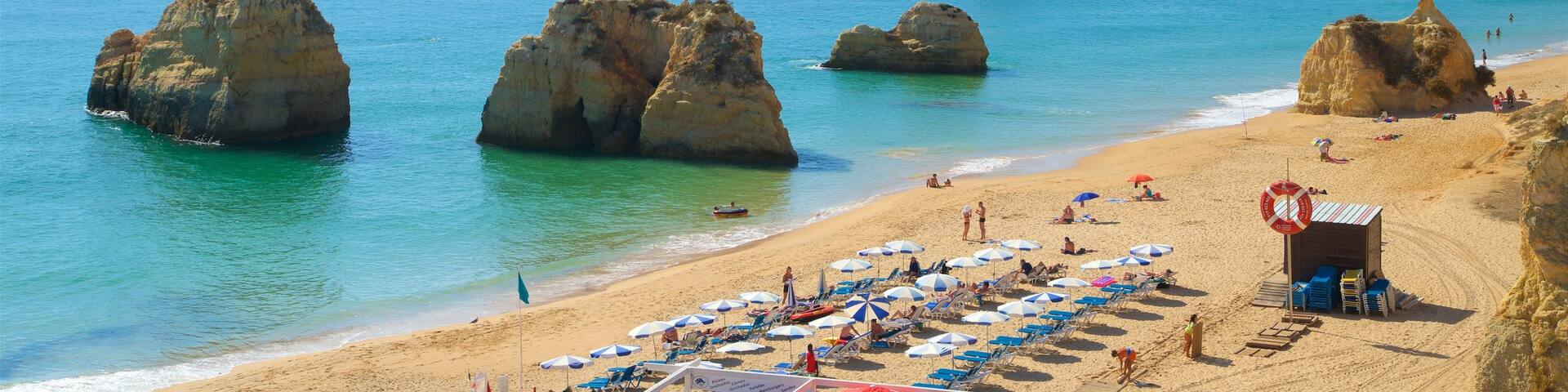 Portimao which includes general coastal views and rugged coastline as well as a small group of people