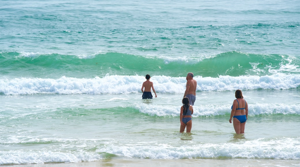 Fuzeta Beach featuring waves and general coastal views as well as a family