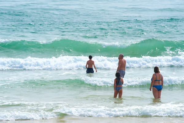 Fuzeta Beach welches beinhaltet Brandung und allgemeine Küstenansicht sowie Familie