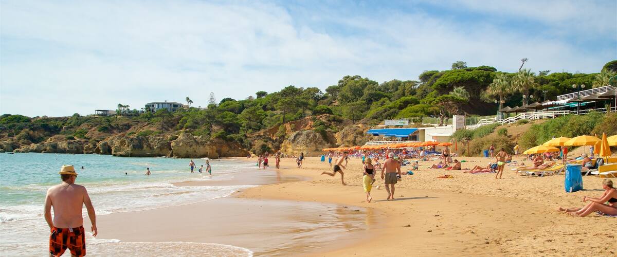 Playa de Oura ofreciendo una playa de arena y vistas generales de la costa y también un pequeño grupo de personas
