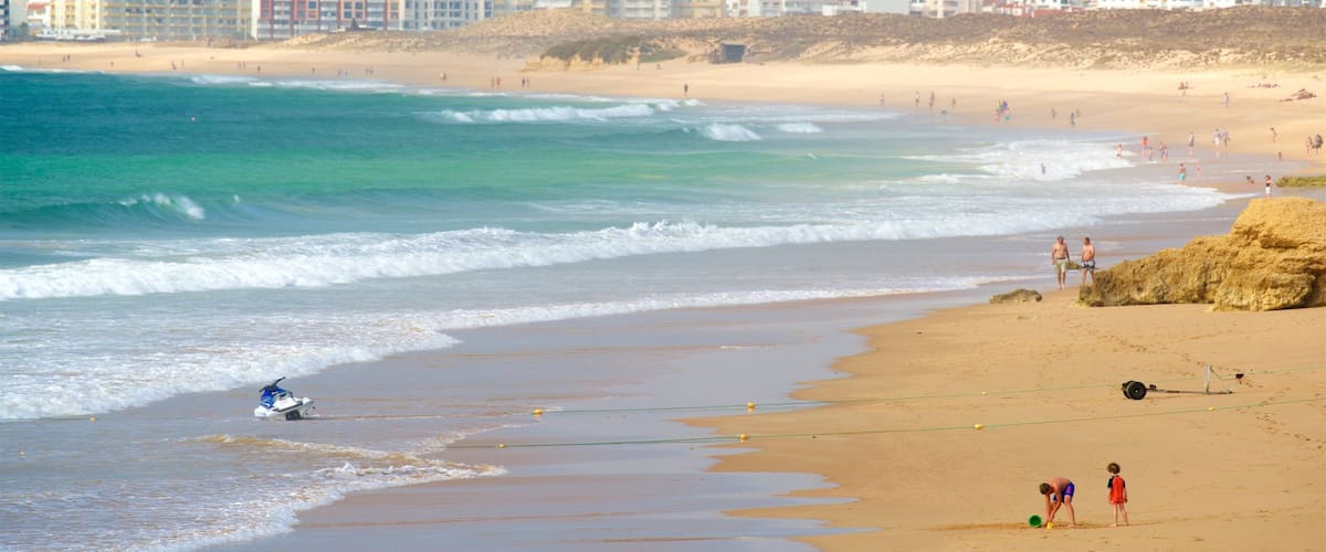 Playa de Gale mostrando una playa de arena, una ciudad costera y surf