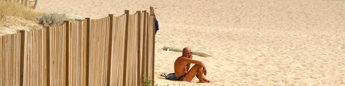 Salgados Beach welches beinhaltet Strand und allgemeine Küstenansicht sowie einzelner Mann