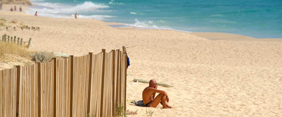 Salgados Beach featuring a sandy beach and general coastal views as well as an individual male