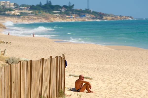 Plage de Salgados mettant en vedette plage et vues littorales aussi bien que homme