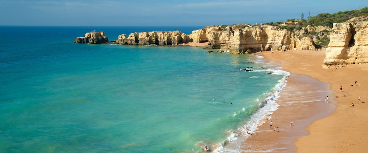 Coelha Beach which includes a sandy beach, rugged coastline and general coastal views
