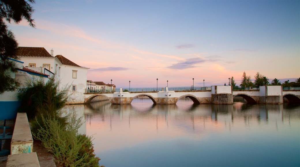 Puente romano ofreciendo un puente, un río o arroyo y un atardecer