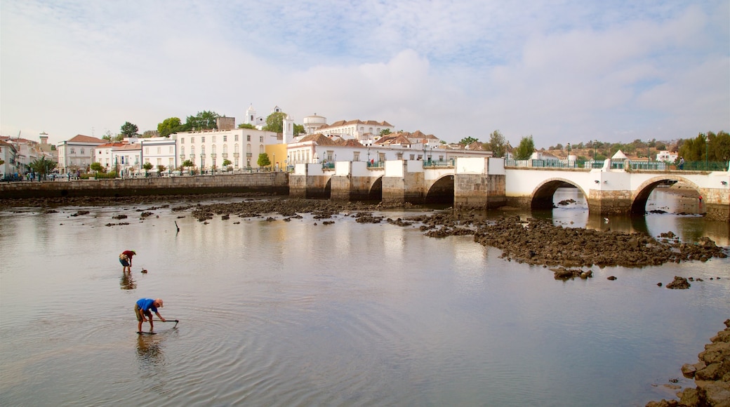 Pont romain mettant en vedette pont et rivière ou ruisseau aussi bien que petit groupe de personnes