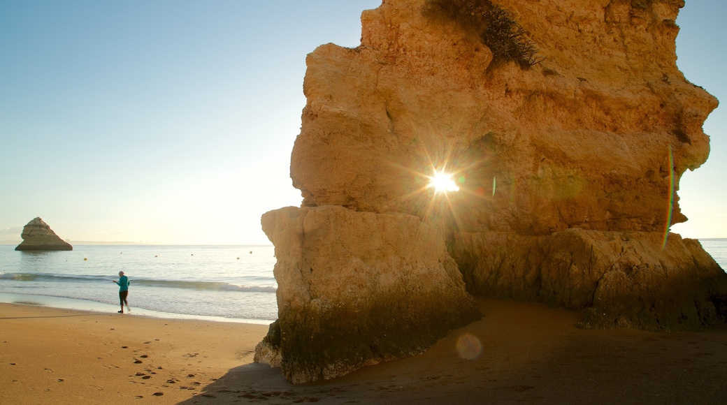 Spiaggia di Dona Ana mostrando tramonto, costa frastagliata e spiaggia