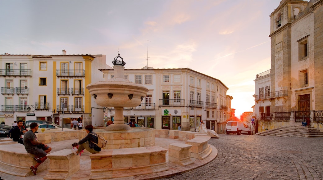 Praça do Giraldo ofreciendo una puesta de sol y una fuente y también un pequeño grupo de personas