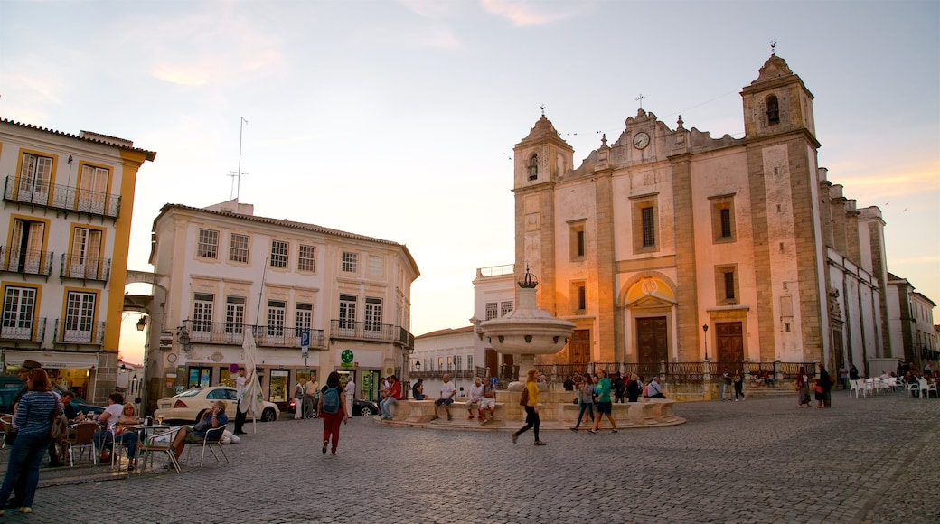 Praça do Giraldo que incluye una iglesia o catedral, una puesta de sol y una fuente