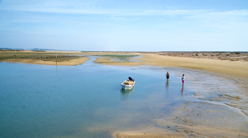 Fuzeta Beach which includes tranquil scenes and a lake or waterhole as well as a couple