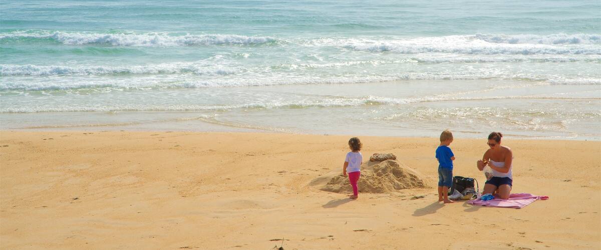 Fuzeta Beach featuring general coastal views and a sandy beach as well as a family