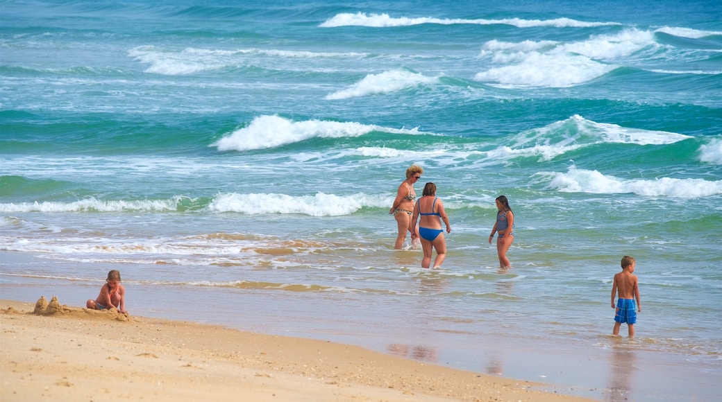 Fuzeta Beach som inkluderar kustutsikter, en sandstrand och bad