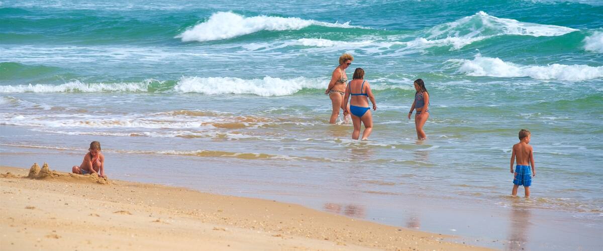 Playa Fuzeta ofreciendo vistas generales de la costa, natación y una playa de arena