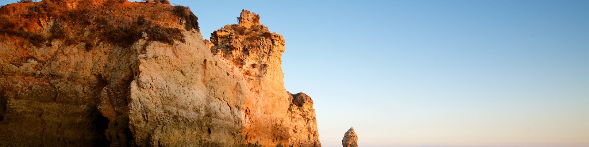 Tres Irmaos Beach showing a sandy beach, a sunset and rocky coastline
