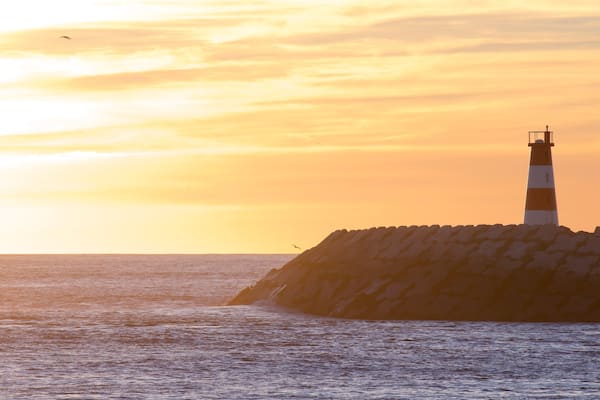 Barra Beach montrant vues littorales, coucher de soleil et phare